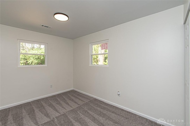 empty room featuring baseboards and carpet