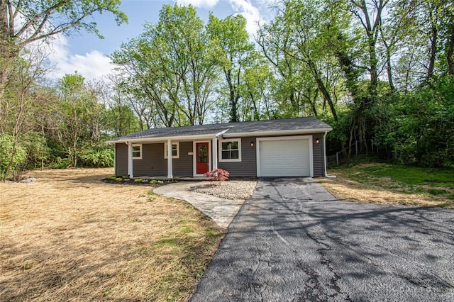 ranch-style house featuring driveway, an attached garage, and covered porch