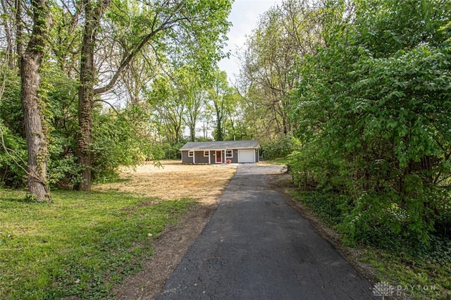 ranch-style home with driveway, a garage, and an outdoor structure
