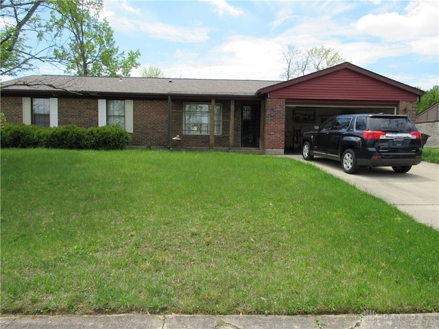3363 Cortez Dr, Dayton, OH 45415 - ranch-style house featuring brick siding, a garage, a front lawn, and driveway