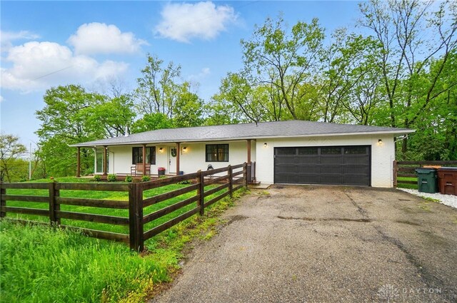 2023 W State Route 63, Lebanon, OH 45036 - single story home with a garage, a fenced front yard, driveway, and a porch