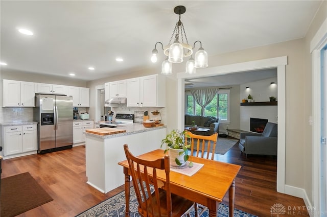 2023 W State Route 63, Lebanon, OH 45036 - dining area with wood finished floors, recessed lighting, a warm lit fireplace, a chandelier, and baseboards