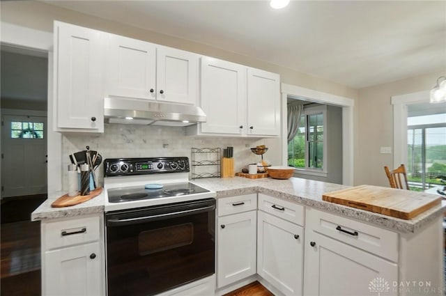 2023 W State Route 63, Lebanon, OH 45036 - kitchen featuring electric stove, under cabinet range hood, a peninsula, white cabinetry, and backsplash