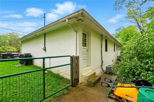 2023 W State Route 63, Lebanon, OH 45036 - view of side of property featuring brick siding, central AC unit, fence, and entry steps