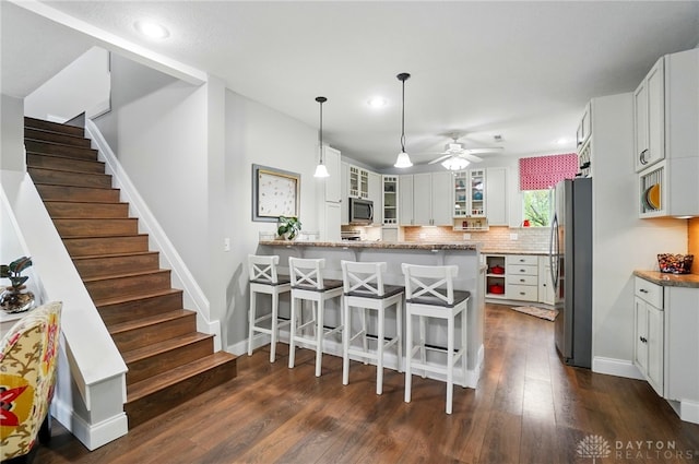 6859 US Highway 62 NE, Washington Court Hous, OH 43160 - kitchen with stainless steel appliances, glass insert cabinets, light stone countertops, a breakfast bar area, and a peninsula