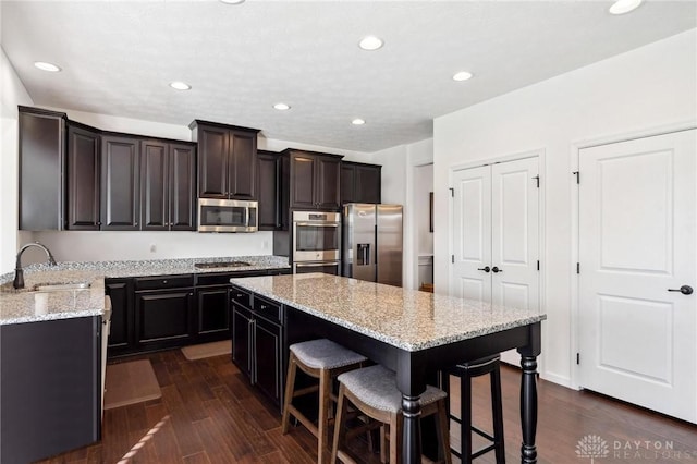 10280 Benjamin Way, Washington Twp, OH 45458 - kitchen with appliances with stainless steel finishes, a sink, a center island, a breakfast bar, and light stone counters
