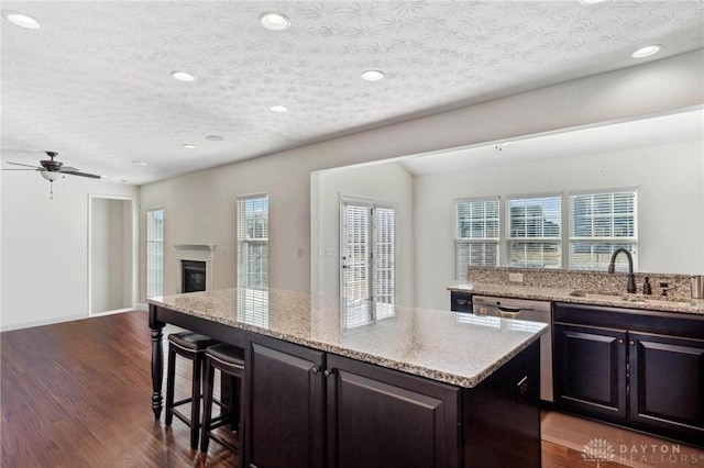 10280 Benjamin Way, Washington Twp, OH 45458 - kitchen with open floor plan, a kitchen island, a kitchen breakfast bar, dark wood-style floors, and light stone countertops