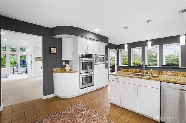 1900 Kresswood Cir, Kettering, OH 45429 - kitchen featuring appliances with stainless steel finishes, a sink, white cabinetry, tile patterned flooring, and decorative light fixtures