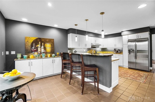 1900 Kresswood Cir, Kettering, OH 45429 - kitchen featuring stainless steel fridge with ice dispenser, under cabinet range hood, light tile patterned floors, white cabinets, and recessed lighting