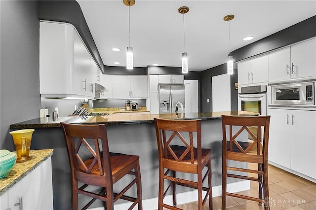 1900 Kresswood Cir, Kettering, OH 45429 - kitchen featuring stainless steel appliances, dark stone countertops, decorative light fixtures, white cabinets, and recessed lighting