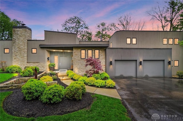 1900 Kresswood Cir, Kettering, OH 45429 - view of front of home with a garage, driveway, stone siding, and a chimney