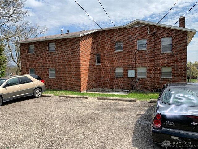 2525 Lakeview Ave, Dayton, OH 45417 - view of property exterior featuring a chimney, uncovered parking, and brick siding