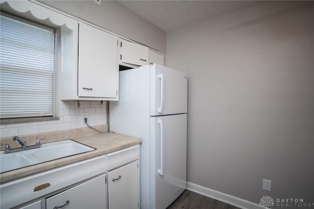 2525 Lakeview Ave, Dayton, OH 45417 - kitchen featuring freestanding refrigerator, white cabinets, light countertops, decorative backsplash, and dark wood-style floors