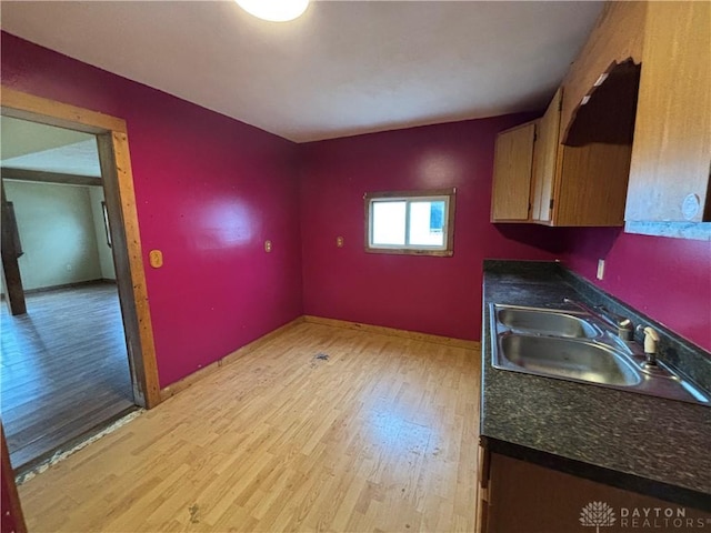616 N Main St, Ansonia, OH 45303 - kitchen with a sink, dark countertops, light wood-style floors, and baseboards