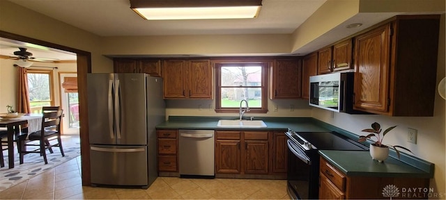 6765 Montpellier Blvd, Centerville, OH 45459 - kitchen with appliances with stainless steel finishes, a sink, dark countertops, ceiling fan, and light tile patterned flooring