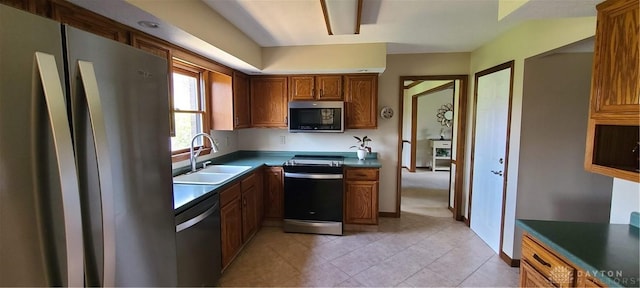 6765 Montpellier Blvd, Centerville, OH 45459 - kitchen with appliances with stainless steel finishes, a sink, brown cabinetry, and dark countertops
