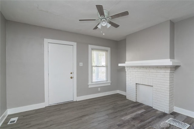 unfurnished living room featuring dark wood finished floors, a ceiling fan, baseboards, and a fireplace