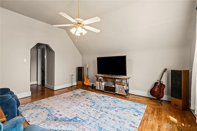 654 S Market St, Troy, OH 45373 - living room featuring wood finished floors, a ceiling fan, vaulted ceiling, arched walkways, and baseboards