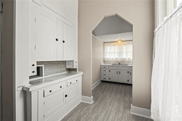 654 S Market St, Troy, OH 45373 - kitchen with white cabinetry, baseboards, tasteful backsplash, and wood finished floors