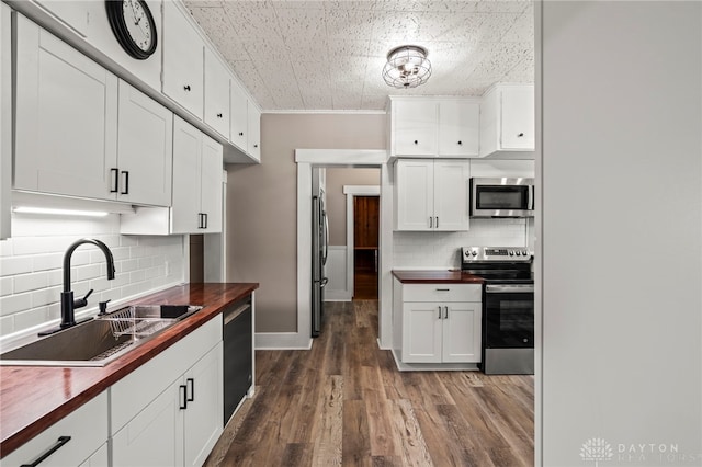 654 S Market St, Troy, OH 45373 - kitchen featuring stainless steel appliances, butcher block countertops, a sink, tasteful backsplash, and white cabinets