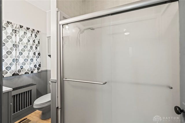 654 S Market St, Troy, OH 45373 - bathroom featuring radiator heating unit, toilet, a stall shower, and wood finished floors