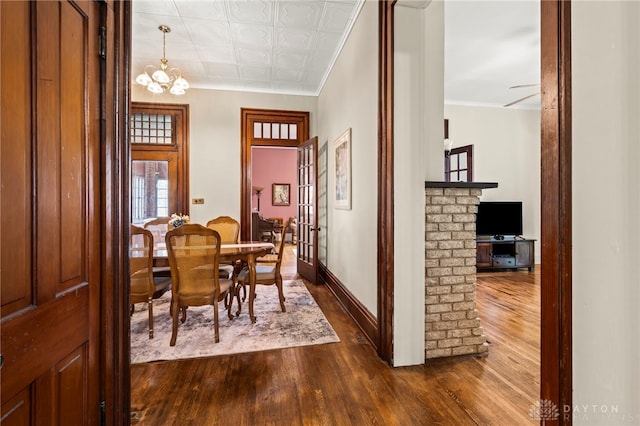 654 S Market St, Troy, OH 45373 - dining space featuring dark wood-type flooring, crown molding, a chandelier, an ornate ceiling, and baseboards