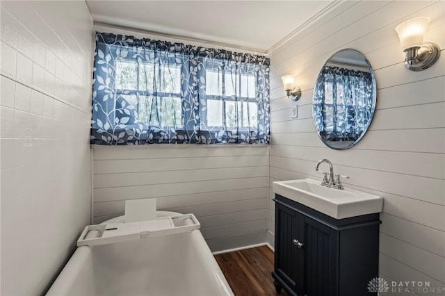 654 S Market St, Troy, OH 45373 - bathroom with healthy amount of natural light, wood finished floors, ornamental molding, vanity, and wood walls
