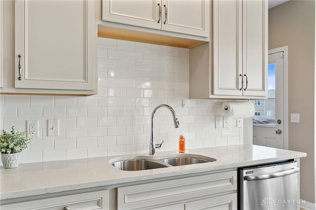 1591 Windham Ln, Beavercreek Township, OH 45385 - kitchen with stainless steel dishwasher, a sink, backsplash, and light stone counters