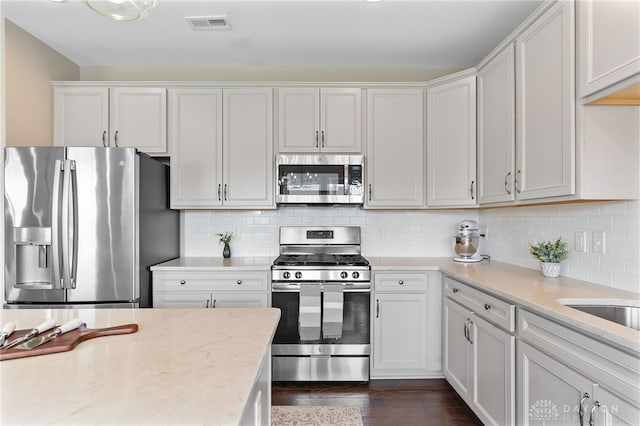 1591 Windham Ln, Beavercreek Township, OH 45385 - kitchen with stainless steel appliances, dark wood-style flooring, white cabinetry, and decorative backsplash