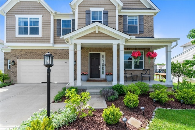 1591 Windham Ln, Beavercreek Township, OH 45385 - view of front of home featuring a porch, an attached garage, brick siding, and concrete driveway