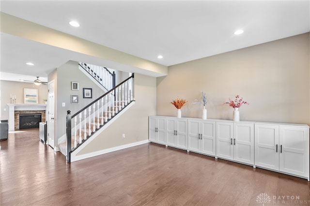 1591 Windham Ln, Beavercreek Township, OH 45385 - bar with ceiling fan, stairway, wood finished floors, a stone fireplace, and baseboards