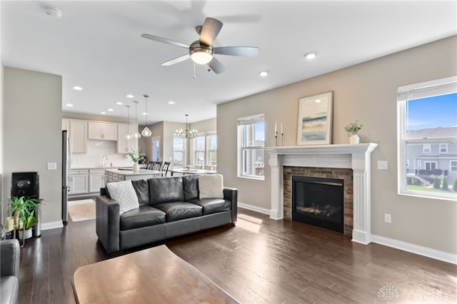 1591 Windham Ln, Beavercreek Township, OH 45385 - living area with ceiling fan, dark wood-style floors, a glass covered fireplace, baseboards, and a chandelier