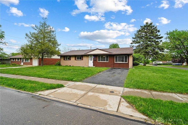 single story home featuring asphalt driveway and a front yard
