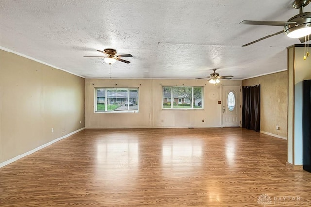 unfurnished living room featuring a ceiling fan, light wood-style floors, a textured ceiling, crown molding, and baseboards