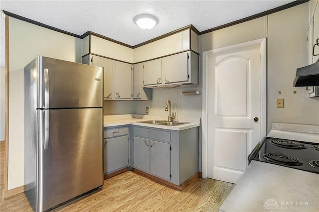 kitchen with freestanding refrigerator, a sink, gray cabinets, light wood finished floors, and crown molding