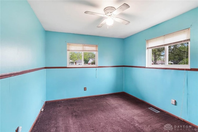 empty room with carpet flooring, a ceiling fan, and baseboards
