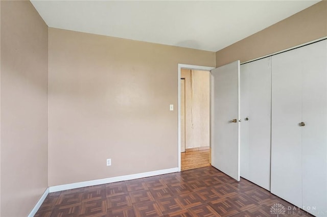unfurnished bedroom with baseboards and a closet
