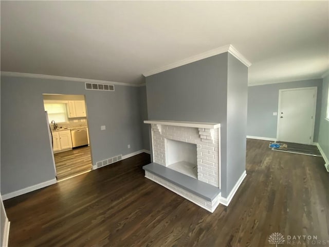 unfurnished living room with crown molding, dark wood finished floors, baseboards, a sink, and a fireplace