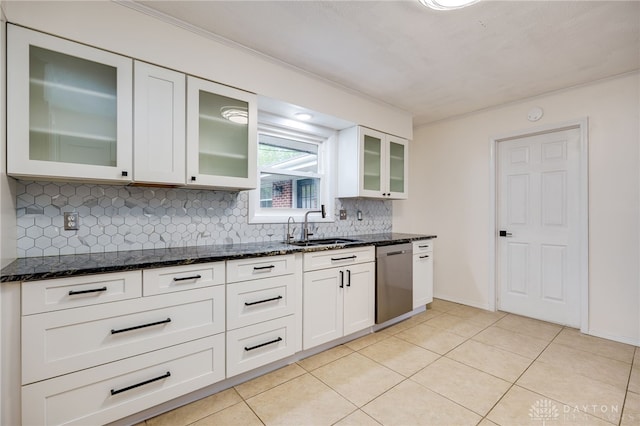 kitchen featuring dishwasher, a sink, dark stone counters, decorative backsplash, and white cabinetry