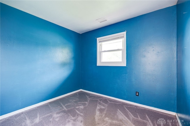 carpeted spare room featuring baseboards