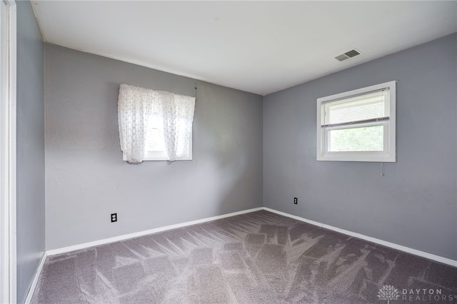 unfurnished room with carpet flooring and baseboards