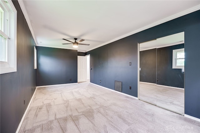 unfurnished room with crown molding, ceiling fan, carpet, and baseboards