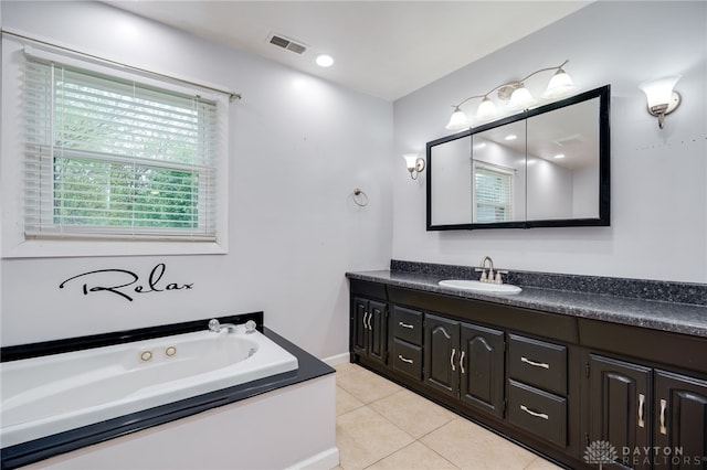 bathroom with vanity, tile patterned floors, and a tub with jets