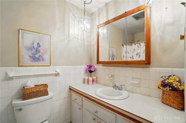 3352 Morning Glory Rd, Dayton, OH 45449 - full bathroom with vanity, toilet, a wainscoted wall, tile walls, and a chandelier