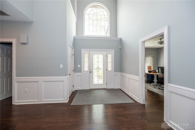 813 Timberlake Ct, Kettering, OH 45429 - foyer entrance featuring wainscoting, dark wood-type flooring, a ceiling fan, a high ceiling, and a decorative wall