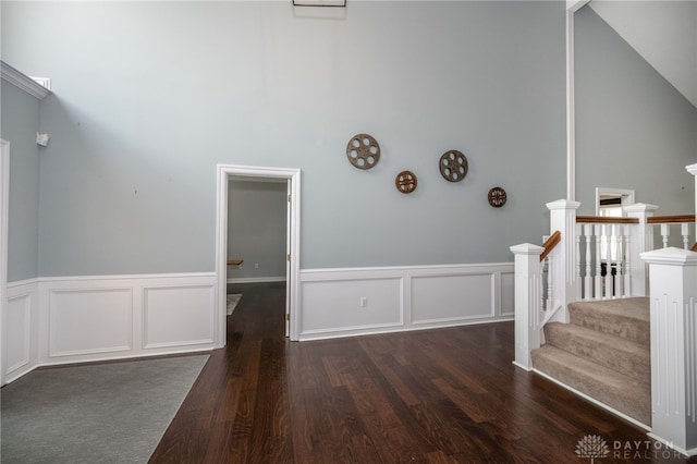 813 Timberlake Ct, Kettering, OH 45429 - stairway featuring wood finished floors, wainscoting, a high ceiling, and a decorative wall