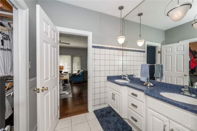 813 Timberlake Ct, Kettering, OH 45429 - ensuite bathroom with tile patterned floors, double vanity, a spacious closet, and tile walls