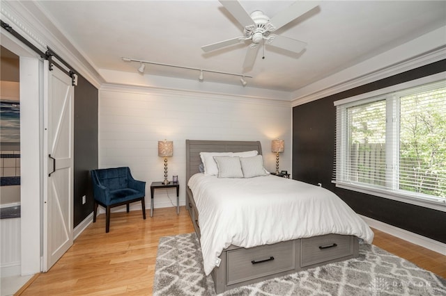813 Timberlake Ct, Kettering, OH 45429 - bedroom with a barn door, track lighting, light wood finished floors, baseboards, and a ceiling fan