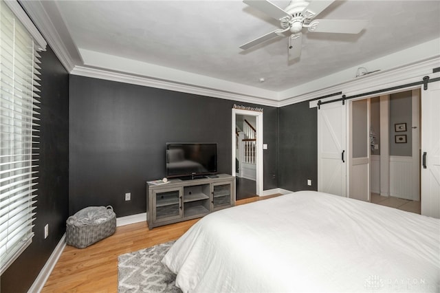 813 Timberlake Ct, Kettering, OH 45429 - bedroom featuring a barn door, wood finished floors, and a ceiling fan