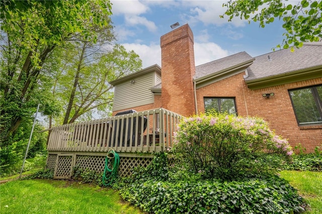 813 Timberlake Ct, Kettering, OH 45429 - back of property featuring brick siding, a chimney, a wooden deck, a shingled roof, and a yard
